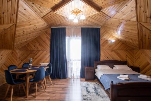 1 dormitorio con 1 cama, mesa y sillas en Sadyba u Halyny en Bukovel
