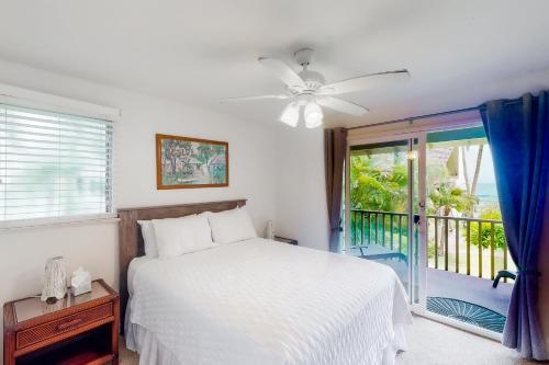 a bedroom with a white bed and a window at Kapa'a Sands 24 in Kapaa
