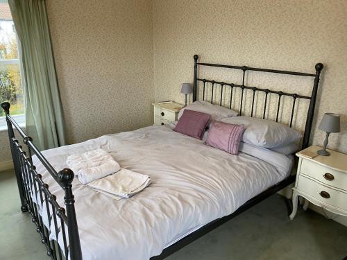 ブリドリントンにあるSouthwold Bridlingtonのベッドルーム1室(白いシーツと紫色の枕が備わるベッド1台付)