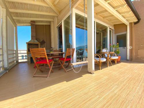 a porch with a wooden table and chairs on it at EKA Luxury Seaview Apartments in Vlorë