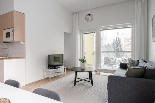 a living room with a couch and a table at 2ndhomes Tampere "Puistotie" Apartment - 2BR Apt with Sauna and Balcony at Tammela Stadium in Tampere