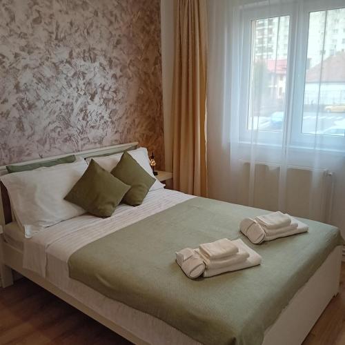 1 cama con 2 toallas y ventana en Harmonyhouse, en Brasov