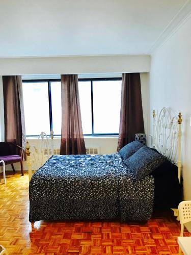 1 dormitorio con 1 cama en una habitación con ventanas en Stylish Montreal Apartment: Comfortable Stay in the Golden Square Mile, en Montreal