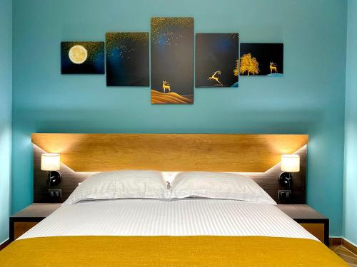 a bedroom with a bed with a blue wall at EKA Luxury Seaview Apartments in Vlorë