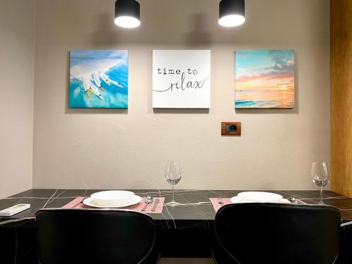 a table with two chairs and three paintings on the wall at EKA Luxury Seaview Apartments in Vlorë