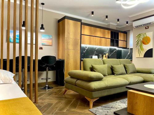 a living room with a green couch and a desk at EKA Luxury Seaview Apartments in Vlorë