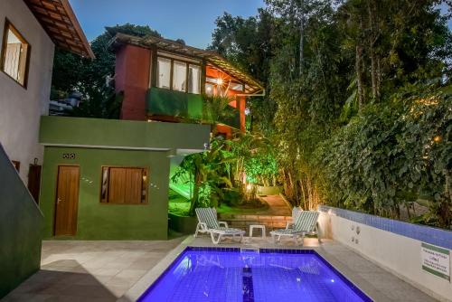 a swimming pool in front of a house at Pousada Sonhos de Praia, Fácil Acesso a Praia, Rua Mucugê e Beco das Cores in Arraial d'Ajuda