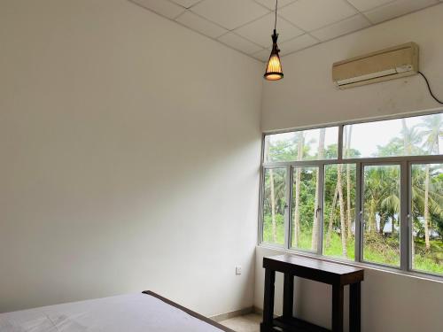 1 dormitorio con cama y ventana grande en Aramba Resort, en Dondra West