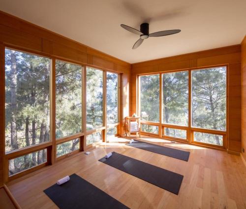 a yoga room with a ceiling fan and large windows at Dhensa Resort in Punākha