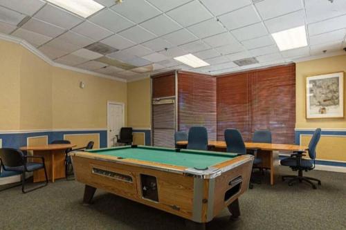 a pool table in a room with tables and chairs at Charming Jax Apt for 4 with free parking in Jacksonville