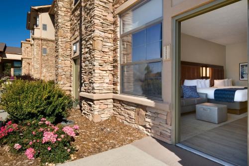 a home with a patio with a bed and a window at ClubHouse Hotel Sioux Falls in Sioux Falls