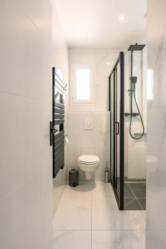 une salle de bain blanche avec toilettes et douche dans l'établissement ANNA : vue sur les vignes, spa exterieur, sans vis-a-vis, à Goudargues