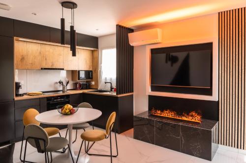 a kitchen with a table and a tv and a fireplace at ANNA : vue sur les vignes, spa exterieur, sans vis-a-vis in Goudargues