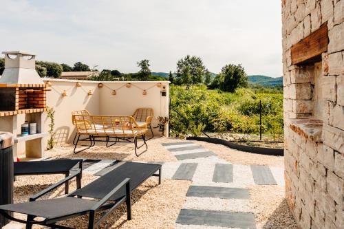 a patio with a table and chairs and a building at ANNA : vue sur les vignes, spa exterieur, sans vis-a-vis in Goudargues
