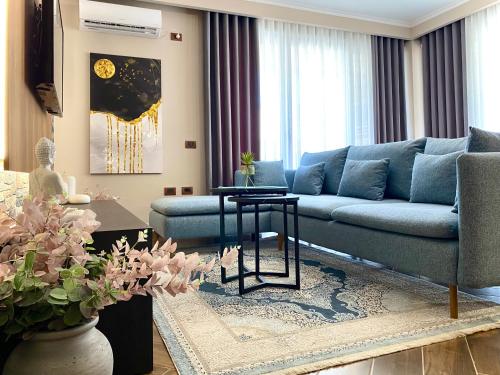 a living room with a blue couch and a table at EKA Luxury Seaview Apartments in Vlorë