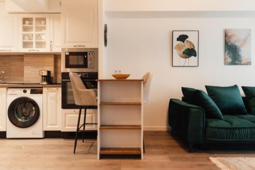 un soggiorno con divano verde e una cucina di VIVO Residence Short Stay a Baia Mare