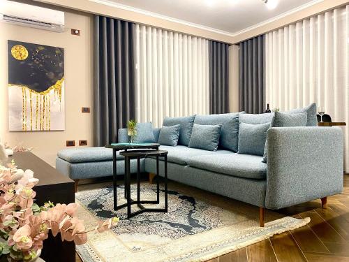 a living room with a blue couch and a table at EKA Luxury Seaview Apartments in Vlorë