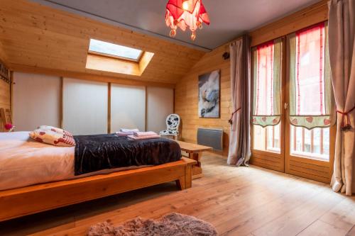 a bedroom with a bed and a chandelier at Chalet Laura in Saint-Marcel