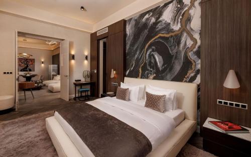 a bedroom with a large bed with a large painting on the wall at Anna Grand Hotel in Balatonfüred