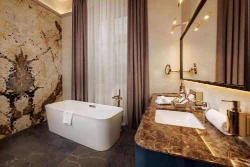 a bathroom with a large white sink and a tub at Anna Grand Hotel in Balatonfüred