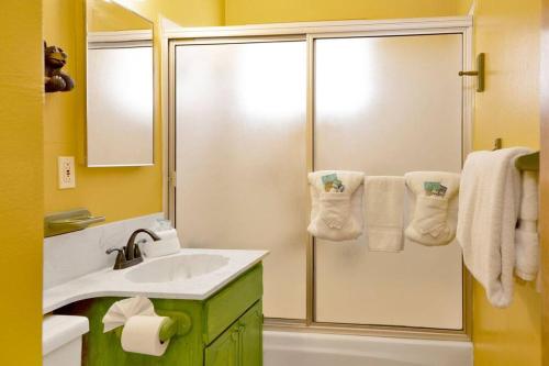 a bathroom with a shower and a sink and towels at Nestled Oaks Cottage~ Bear Mountain Resort Chalet~ in Big Bear Lake