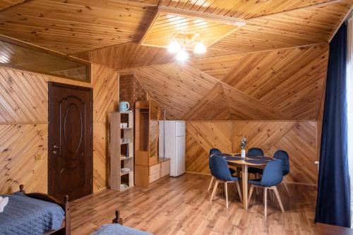 a room with a wooden ceiling with a table and chairs at Sadyba u Halyny in Bukovel