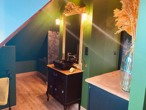 La salle de bains est pourvue d'un lavabo et d'un miroir sur une table. dans l'établissement La Green suite, à Lys-lès-Lannoy