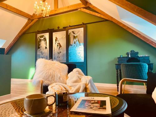 a living room with green walls and a table at La Green suite in Lys-lès-Lannoy