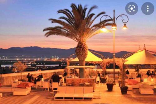 a resort with a palm tree on the roof at Castello Attic Sunset Terrace in Cagliari