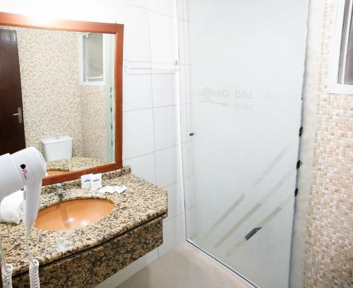 La salle de bains est pourvue d'un lavabo et d'une douche avec un miroir. dans l'établissement Acqua Floripa Morro das Pedras SC, à Florianópolis