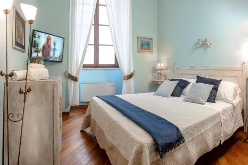 una camera da letto con un letto con pareti blu e una finestra di Il Casato a Siena