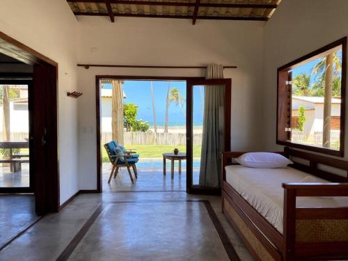 Un dormitorio con una cama y una puerta corrediza de vidrio. en Casa Cajueiro - Os Navegantes, en Icaraí