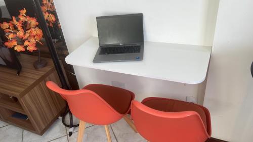 a desk with two chairs and a laptop on it at Apartamento Vista Mar Salvador - Vista fantástica in Salvador