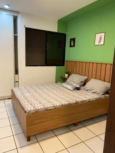 um quarto com uma cama e uma parede verde em Oásis à Beira-Mar em São Luís