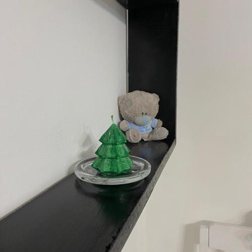 a teddy bear sitting on a shelf next to a christmas tree at Квартира у Старому місті in Kamianets-Podilskyi