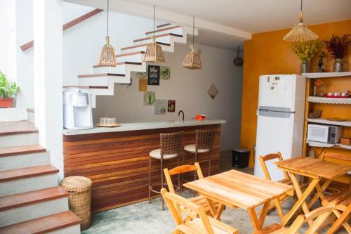 eine Küche mit einem Tisch und einem Kühlschrank in der Unterkunft Pousada Bilica in Arraial d'Ajuda