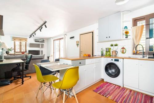 a kitchen with white cabinets and a table and chairs at Private Garden Home next to the beach and market in Athens