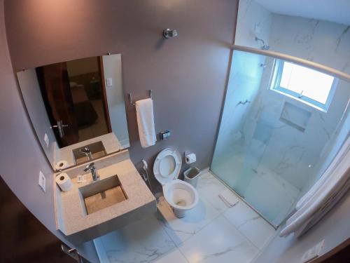 a bathroom with a sink and a toilet and a shower at Lito Palace Hotel in Registro