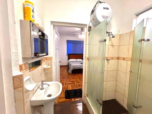 a bathroom with a sink and a shower and a bedroom at Colonial Style Apartment in San Isidro in Lima