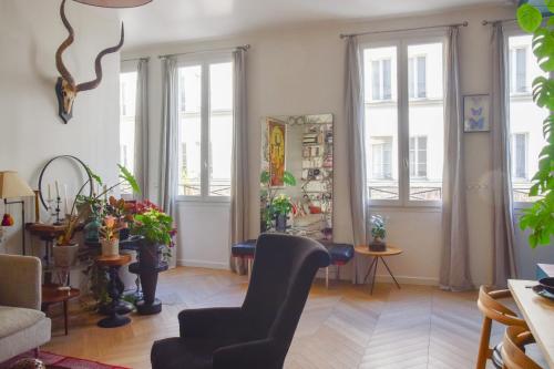 a living room with large windows and a chair at Contemporary T3 in the heart of Bastille Paris - Welkeys in Paris