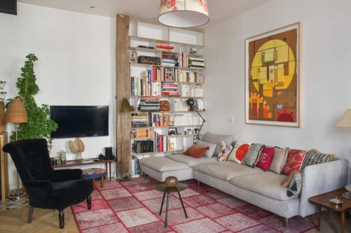 a living room with a couch and a tv at Contemporary T3 in the heart of Bastille Paris - Welkeys in Paris