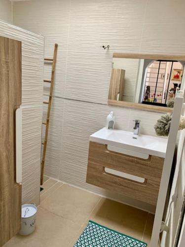 une salle de bain avec un lavabo et un miroir dans l'établissement Charmante villa avec une âme., à Pignan