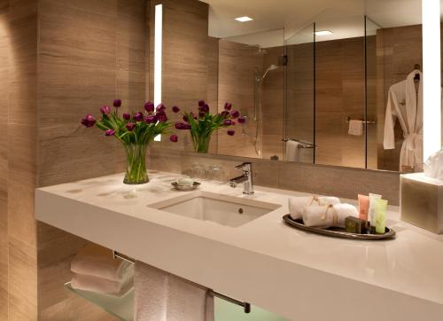 a bathroom with a sink and a vase of flowers at Millennium Hilton New York One UN Plaza in New York