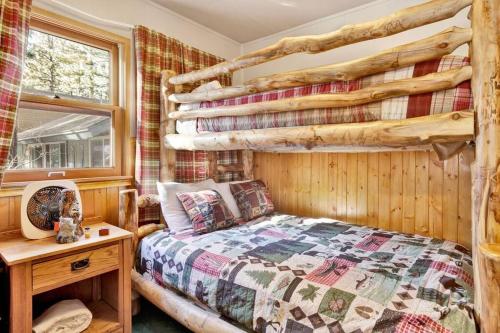 a bedroom with a bed and a wooden wall at Bear Paw Cottage~ Hot Tub~ Resort Base Camp Cottage~ in Big Bear Lake