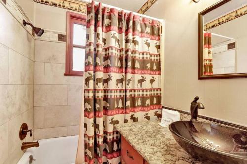 a bathroom with a sink and a shower curtain at Bear Paw Cottage~ Hot Tub~ Resort Base Camp Cottage~ in Big Bear Lake