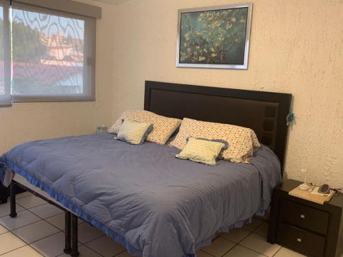 1 dormitorio con 1 cama con sábanas y almohadas azules en Lomas de Cocoyoc , Family- Friendly en Cocoyoc