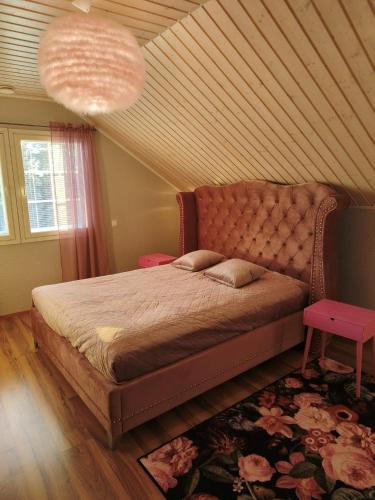 a bedroom with a large bed with a large headboard at Huvila Lohja in Lohja