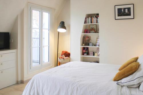 une chambre avec un lit blanc et une fenêtre dans l'établissement 26 m love cocoon with Eiffel Tower view, à Paris