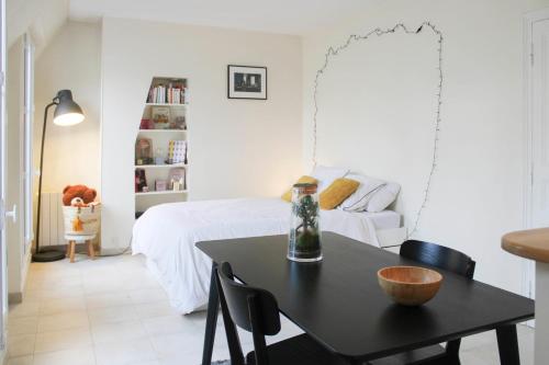 une chambre avec un lit et une table avec des chaises dans l'établissement 26 m love cocoon with Eiffel Tower view, à Paris