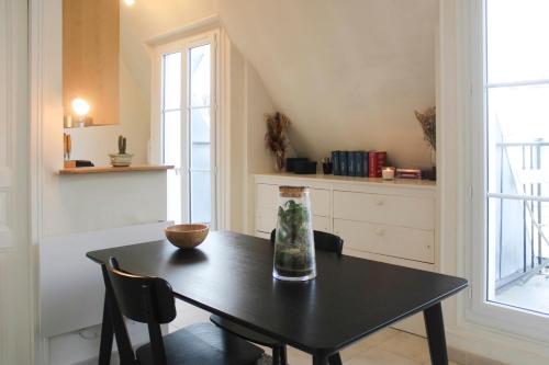 une salle à manger avec une table et une fenêtre dans l'établissement 26 m love cocoon with Eiffel Tower view, à Paris